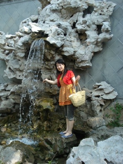 An artificial waterfall, as beautiful as the real waterfall in nature and one so young enjoying it, as if it were.